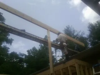 Carpenter setting a ridge beam over a new addition frame — Ice Dam Removal by Roofing Brothers in Annville