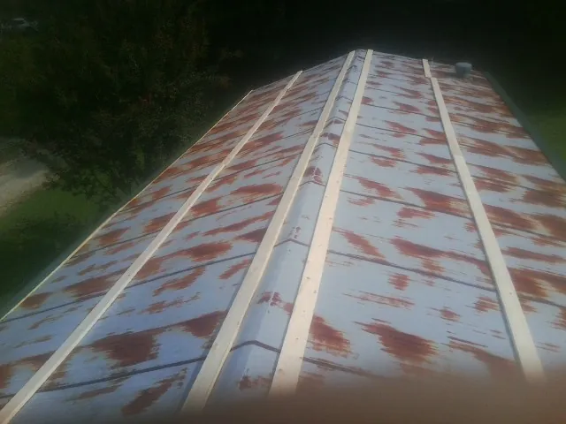 Rusted metal roof panels with new wood purlins before replacement in Annville