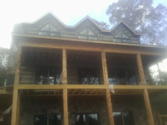Dormers and porch framing on a large log home under construction — Roof Coating work by our crew in Annville